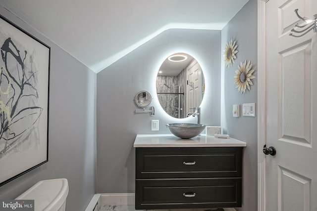 bathroom with toilet, lofted ceiling, and vanity