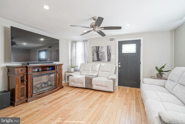 living room with hardwood / wood-style flooring and ceiling fan