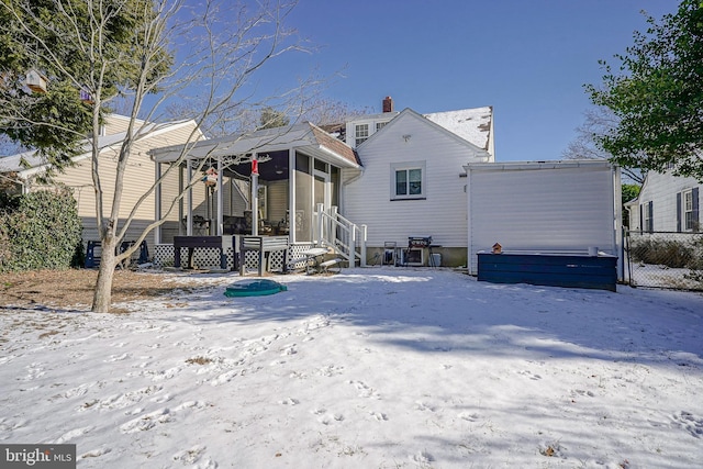 snow covered house with a sunroom