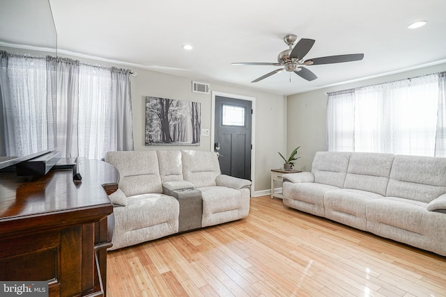 living room featuring light hardwood / wood-style floors and ceiling fan