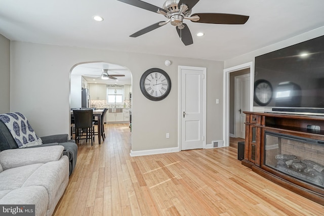 living room with light hardwood / wood-style floors and ceiling fan