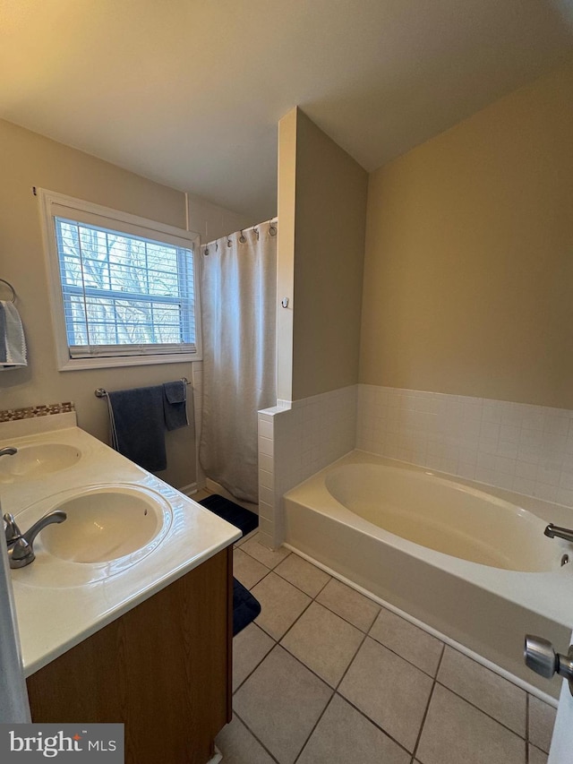 bathroom with vanity, a washtub, and tile patterned floors