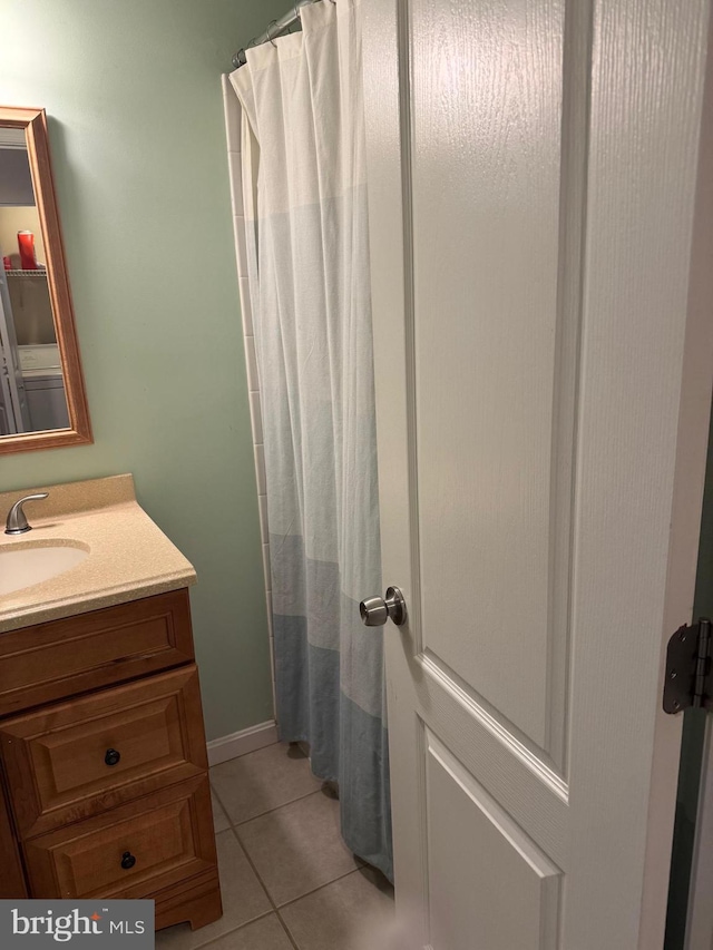 bathroom with walk in shower, tile patterned floors, and vanity