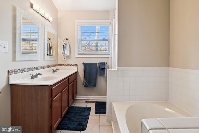 bathroom featuring tile patterned flooring, vanity, a tub, and a healthy amount of sunlight