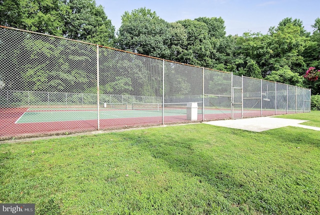 view of sport court with a yard