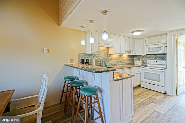 kitchen featuring white cabinetry, pendant lighting, white appliances, and kitchen peninsula