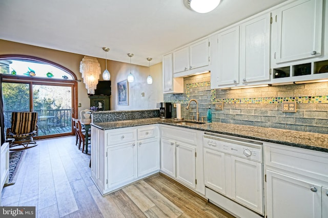 kitchen with hanging light fixtures, dark stone countertops, dishwasher, kitchen peninsula, and white cabinets