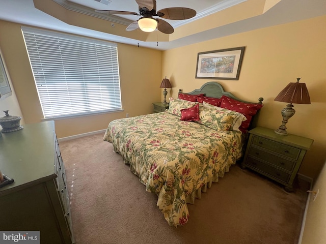 carpeted bedroom featuring ceiling fan, crown molding, and a tray ceiling