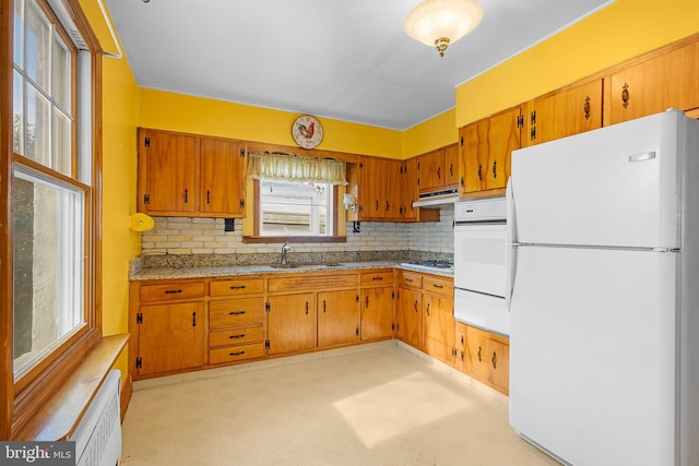 kitchen featuring tasteful backsplash, sink, radiator heating unit, and white appliances