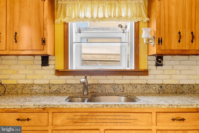 kitchen featuring light stone countertops and sink