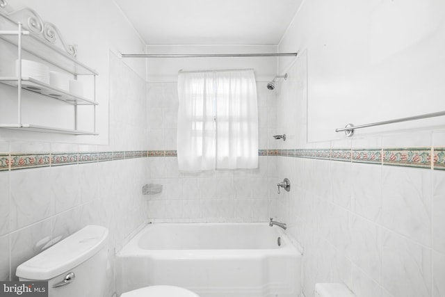 bathroom featuring tile walls, tiled shower / bath combo, and toilet