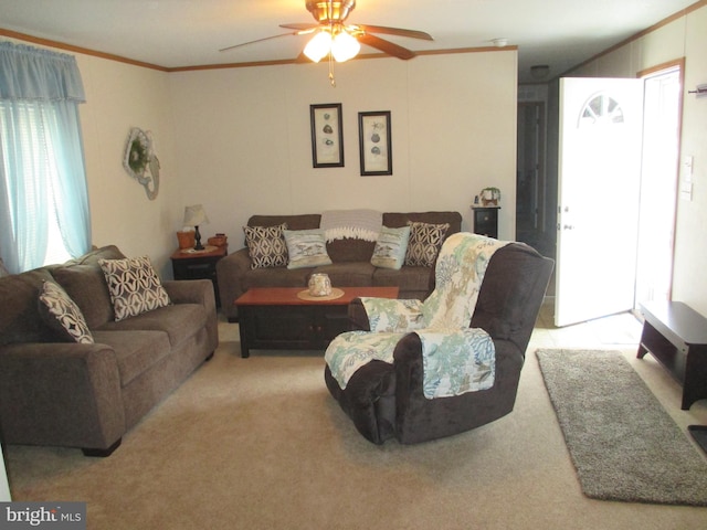 living room featuring ceiling fan, light colored carpet, and crown molding