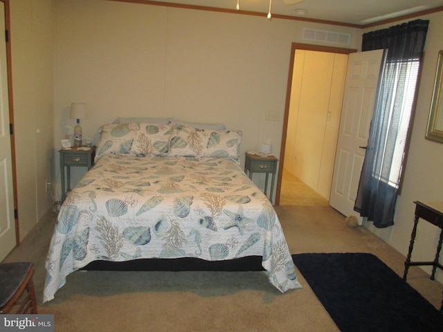 bedroom with light colored carpet and ornamental molding