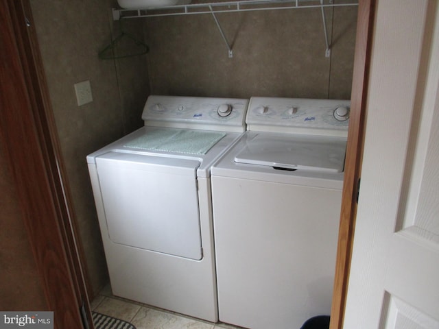 laundry room with washer and dryer and light tile patterned floors