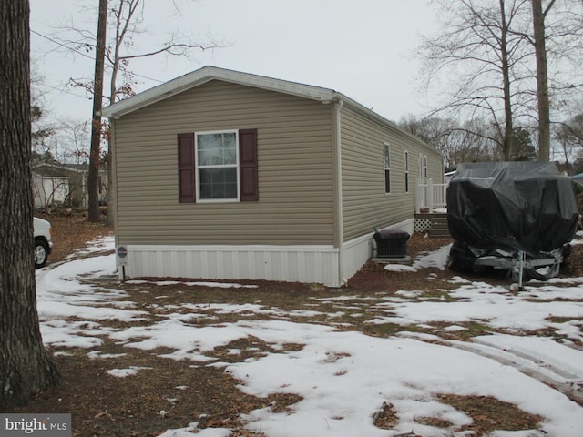 view of snow covered exterior with central AC unit