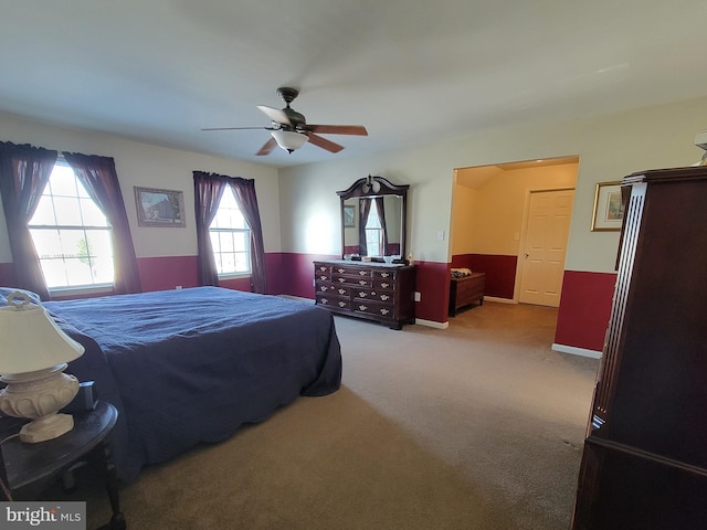 carpeted bedroom featuring multiple windows and ceiling fan