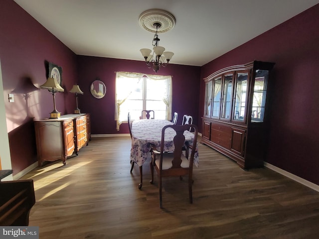 dining space with dark wood-type flooring and a notable chandelier