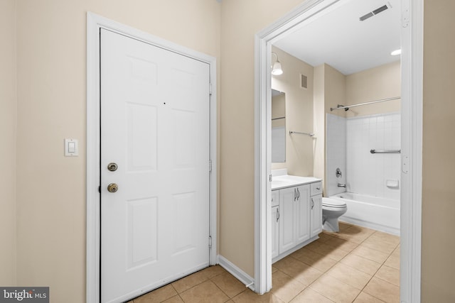 full bathroom with tiled shower / bath, vanity, toilet, and tile patterned flooring