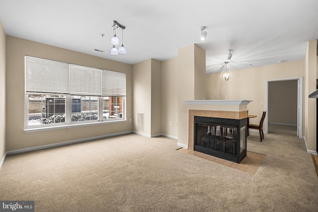 unfurnished living room with light colored carpet and a fireplace