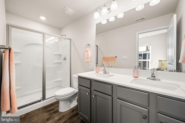 bathroom featuring toilet, hardwood / wood-style floors, an enclosed shower, and vanity