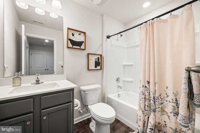 full bathroom with hardwood / wood-style flooring, toilet, vanity, and shower / tub combo