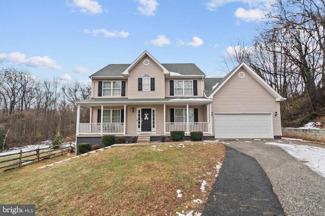 view of front of property featuring a front lawn, a garage, and a porch