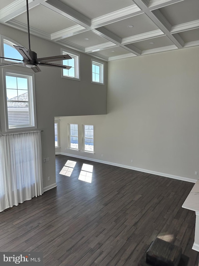 unfurnished room with beamed ceiling, coffered ceiling, ornamental molding, dark wood-type flooring, and ceiling fan