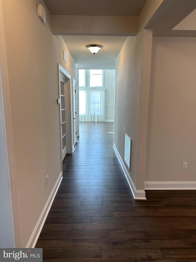 hallway featuring dark hardwood / wood-style flooring and beam ceiling