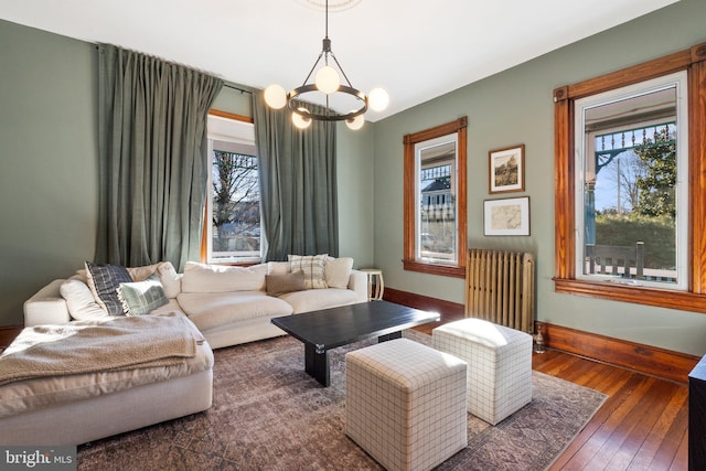 living room with an inviting chandelier, radiator, and dark hardwood / wood-style floors