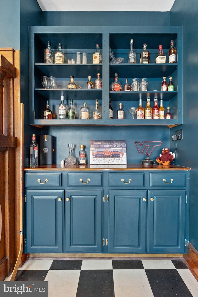 bar featuring blue cabinetry and built in shelves