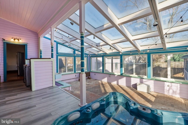 sunroom featuring a hot tub, coffered ceiling, and vaulted ceiling with skylight