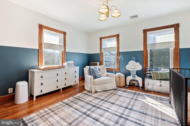 living area with an inviting chandelier and wood-type flooring