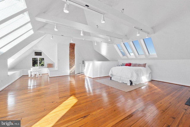 unfurnished bedroom with lofted ceiling with skylight and light hardwood / wood-style floors