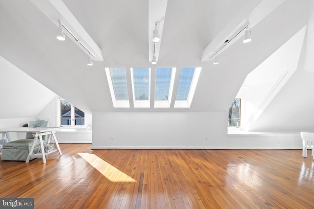 additional living space with lofted ceiling and hardwood / wood-style floors