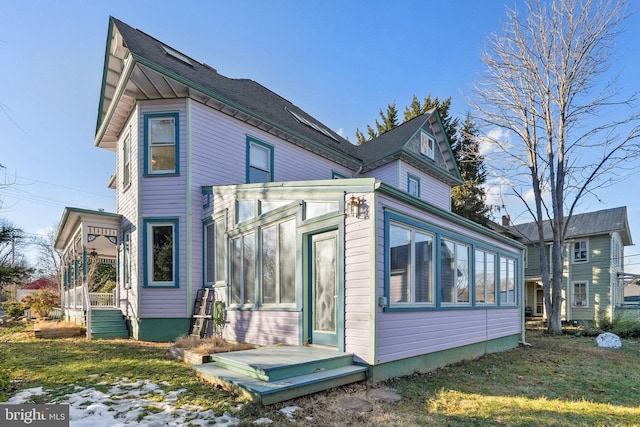 exterior space featuring a yard and a sunroom