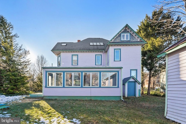 back of house with a yard and a sunroom