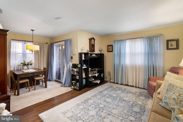 living room with dark hardwood / wood-style floors and a notable chandelier