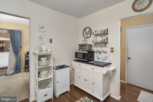 kitchen featuring white cabinetry and dark hardwood / wood-style floors