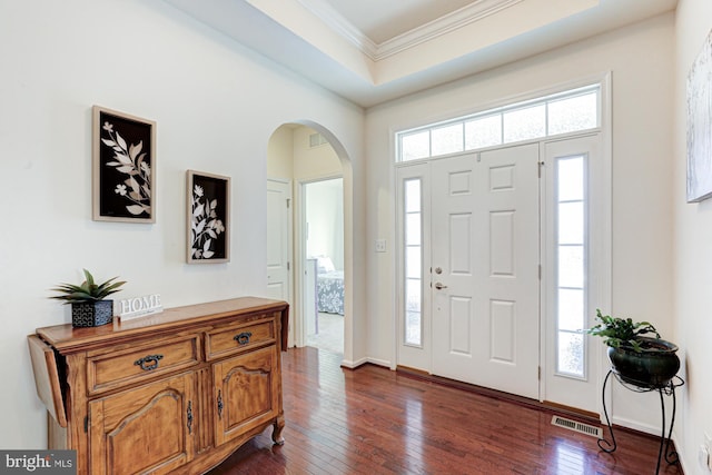 foyer featuring a raised ceiling, dark hardwood / wood-style floors, and ornamental molding