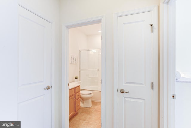 full bathroom with combined bath / shower with glass door, toilet, and vanity