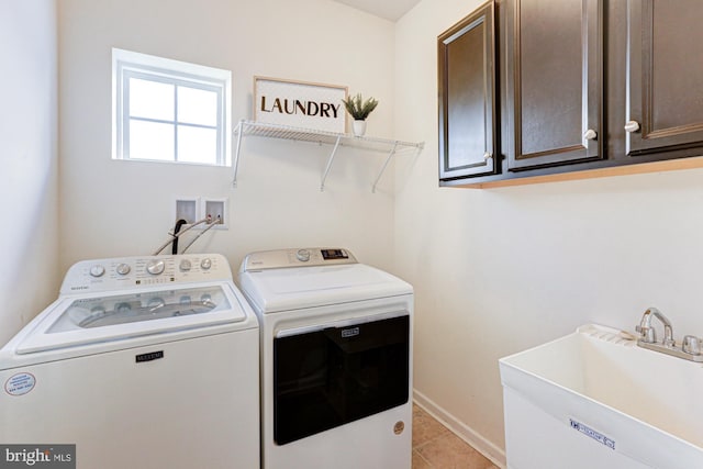 laundry room with cabinets, sink, washer and clothes dryer, and light tile patterned floors