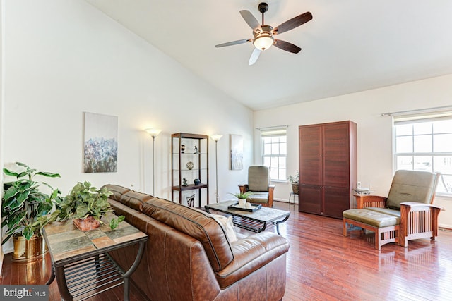 living room featuring hardwood / wood-style floors, high vaulted ceiling, and ceiling fan