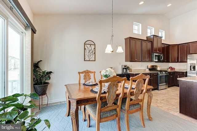 dining space with high vaulted ceiling