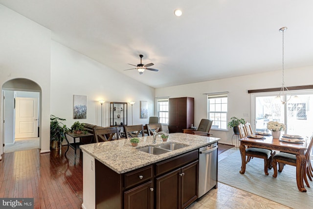 kitchen featuring dark brown cabinets, stainless steel dishwasher, pendant lighting, sink, and an island with sink