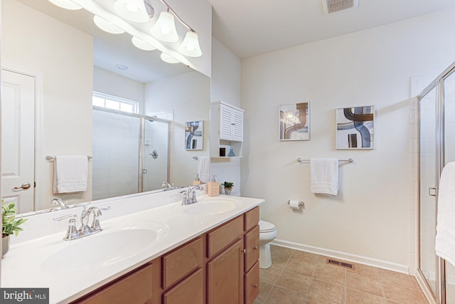 bathroom featuring vanity, toilet, and a shower with door