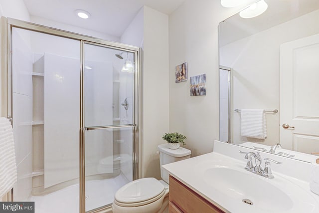 bathroom featuring a shower with door, toilet, and vanity