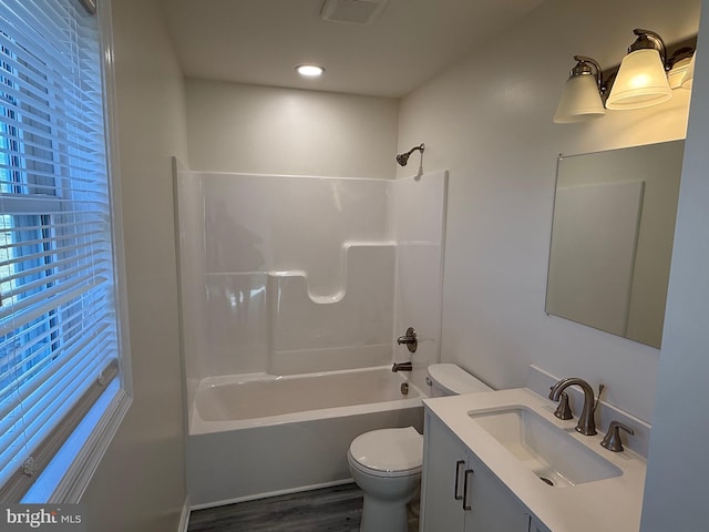 full bathroom featuring toilet, hardwood / wood-style flooring, bathtub / shower combination, and vanity