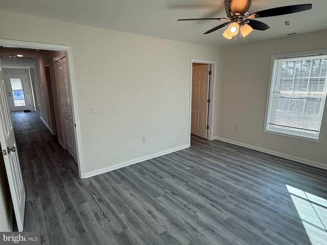 empty room with dark wood-type flooring and ceiling fan