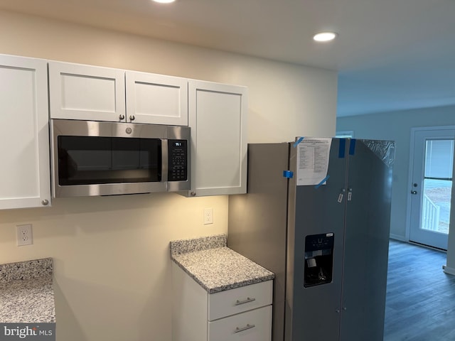 kitchen featuring light hardwood / wood-style floors, stainless steel appliances, white cabinetry, and light stone counters