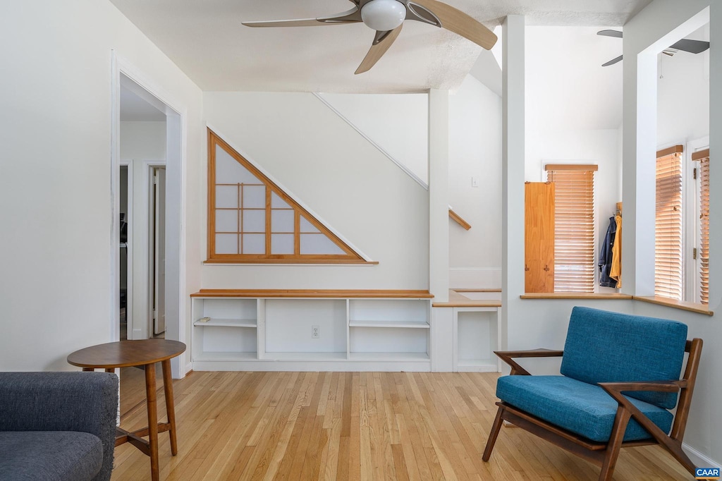 living area with ceiling fan and light hardwood / wood-style flooring